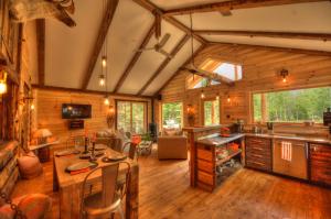 Cabaña de madera con cocina y sala de estar con suelo de madera. en Le St Bernard - Les Chalets Spa Canada, en La Malbaie