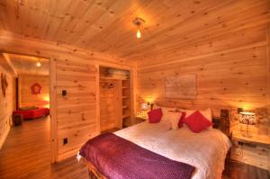 a bedroom with a bed in a wooden cabin at Le St Bernard - Les Chalets Spa Canada in La Malbaie