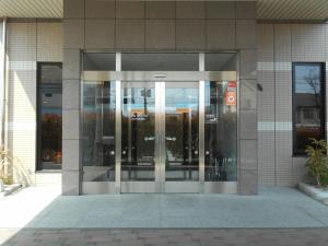 uma entrada para um edifício de escritórios com portas giratórias em Hotel Route-Inn Iwakiizumi Ekimae em Iwaki