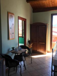 Habitación con mesa, sillas y puerta en Sa Domo De Alene, en Bosa