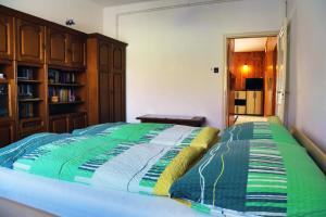 バラトンマーリアフュルドゥーにあるPingvin Cukrászda Apartmanのベッドルーム1室(カラフルなキルトのベッド1台付)