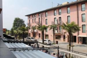 a group of people standing outside of a pink building at Suite Mavino Appartamenti in Sirmione