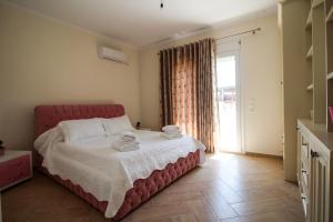 a bedroom with a red bed with towels on it at Villa Aleandro in Ksamil +67 photos