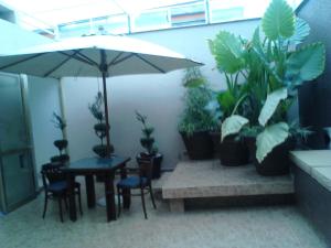 Habitación con mesa, macetas y sombrilla. en Mansion Havre, en Ciudad de México