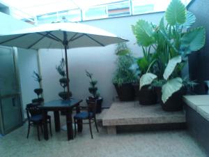 a room with a table and potted plants and an umbrella at Mansion Havre in Mexico City