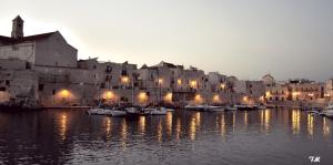 a group of boats in the water in front of a building at Il Da Vinci Apartment in Giovinazzo