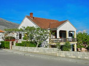 a white house with a brick retaining wall at Studio Jegdic in Trebinje