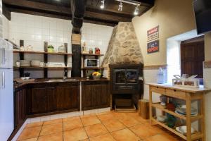 una cocina con armarios de madera y un gran horno de piedra. en Natural&Mente El Tomillar, en Pasarón