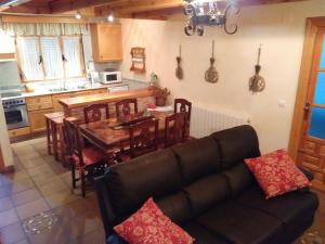 a living room with a couch and a table and a kitchen at Casa Rural Marques de Cerralbo in Santa María de Huerta