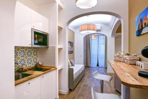 ソレントにあるCuore di Sorrento Suitesのキッチン、リビングルーム(ベッド1台、テーブル付)