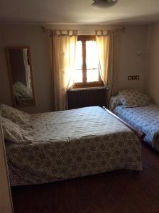 1 dormitorio con 2 camas y ventana en Auberge des Pyrénées, en Sainte-Marie-de-Campan