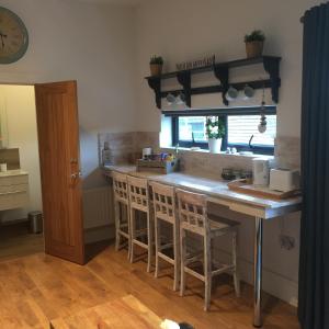 a kitchen with a counter and a kitchen island with stools at Willow Court Farm Studio West & Petting Farm, 8 mins to Legoland & Windsor, 15 mins to Lapland UK in Windsor