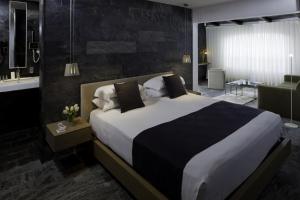 a bedroom with a large bed and a living room at Hotel Boutique Ses Pitreras in San Antonio Bay