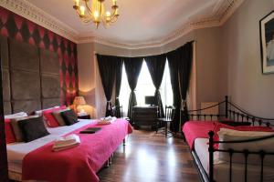 a bedroom with two beds and a chandelier at The Sandaig in Edinburgh