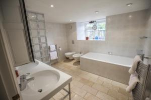 uma casa de banho com uma banheira, um lavatório e um WC. em Grosvenor Villa em Bath