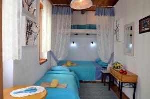 two beds in a room with blue sheets and a table at Hera Studios in Chania