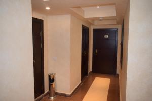 a hallway with two black doors and a pole at Omar El Khayam Al Minya Hotel - Luxury Accommodation in Minya