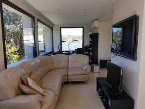 a living room with a couch and a television at Mougins Mas lumineux vue sur le village in Mougins