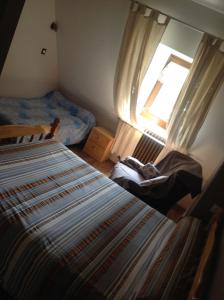 a bedroom with two beds and a window at Auberge des Pyrénées in Sainte-Marie-de-Campan