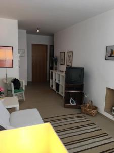a living room with a couch and a tv at Monte Gordo Flat in Monte Gordo