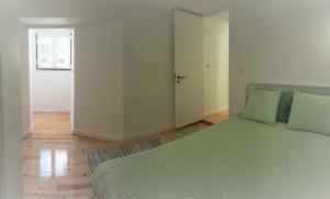 um quarto com uma cama com lençóis verdes e uma porta em Stay In Alfama em Lisboa