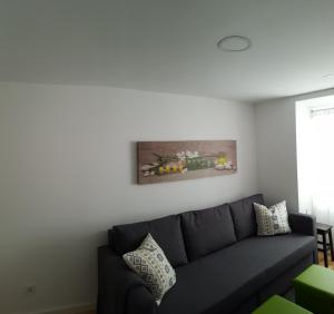 uma sala de estar com um sofá e uma pintura na parede em Stay In Alfama em Lisboa