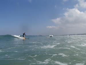 een man die op een surfplank in de oceaan op een golf rijdt bij Villa Puri Burung in Canggu