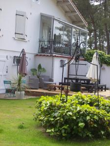 a patio with two umbrellas and a table and chairs at Villa Sunshine in Biscarrosse-Plage