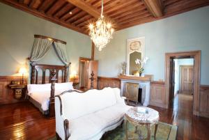 een woonkamer met een bed en een kroonluchter bij Hotel Castillo de Arteaga in Gautegiz Arteaga