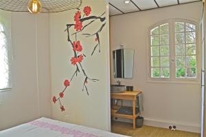 a bedroom with a bed with red flowers on the wall at L'Escalère in Arnaud-Guilhem