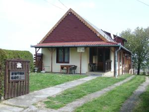 une petite maison avec un panneau devant elle dans l'établissement Zalakaros Panoráma Apartmanok, à Zalakaros