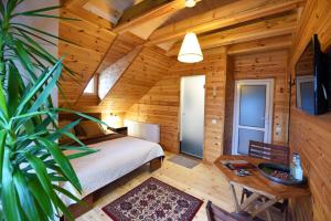 a bedroom in a log cabin with a bed and a table at Žuvienės Pašiūrė in Rubikiai