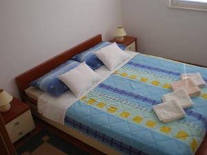 a bedroom with a bed with blue sheets and pillows at Apartments Sonja Murter Croatia in Murter