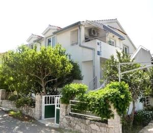 a white building with a gate in front of it at Apartments Sonja Murter Croatia in Murter