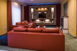 salon z czerwoną kanapą i telewizorem w obiekcie Hotel Sperling mit E-Ladestation w mieście Spira