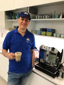 a man in a blue shirt holding a coffee cup at Al Parco Primavera B&B in Sorrento