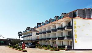 a building with balconies and cars parked in a parking lot at Unluselek Hotel in Anamur