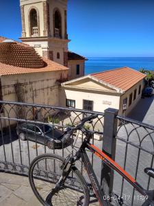 ein Fahrrad, das vor einem Gebäude mit einem Uhrturm geparkt ist in der Unterkunft Villa Melina Appartamenti in Santa Maria di Castellabate