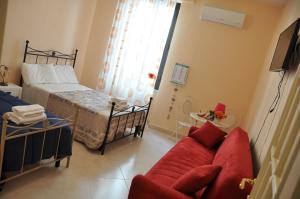 a living room with a red couch and a bed at Il Nuovo in San Severo