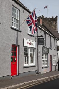 a british flag flying in front of a building at The First Hurdle Guest House in Chepstow