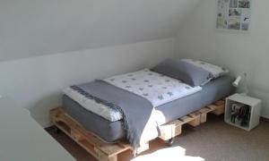 a bed sitting on a wooden platform in a room at Gemütliche Ferienwohnung in Bad Fallingbostel