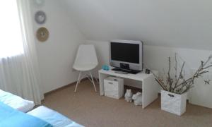 Schlafzimmer mit einem Schreibtisch, einem TV und einem Stuhl in der Unterkunft Gemütliche Ferienwohnung in Bad Fallingbostel