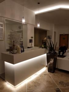 a lobby with a white counter with lights in it at Hotel Solemare in Cesenatico
