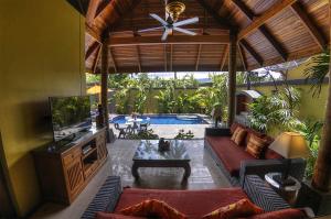 a living room with a couch and a tv at Villa Amber in Laem Set Beach