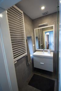 łazienka z umywalką i lustrem w obiekcie Apartament Paderewskiego 11 w Świnoujściu