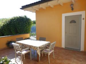 - une table et des chaises sur la terrasse d'une maison dans l'établissement Agriturismo Cascina Serra, à Cossano Belbo