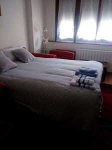 a bedroom with a bed with two pillows on it at Living Gijon & Parking in Gijón