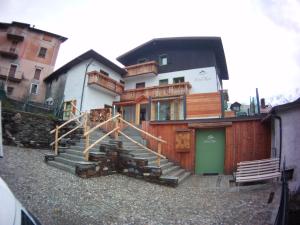 una casa con escaleras de madera y una puerta verde en Hotel Riva Sport & Wellness, en Vione