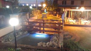 a man standing next to a pool of water at night at Locanda del Principe in Soriano nel Cimino