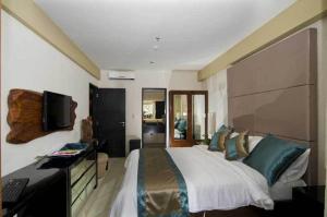 Un dormitorio con una cama, un escritorio y un televisor. en Kuta Luxury Residence, en Kuta 5 fotos más